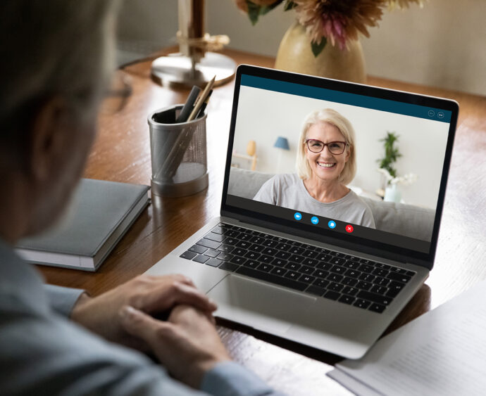 Happy 50s years old couple chatting via video call from home. Laptop screen view of middle aged woman talking to husband or father. Family speaking at webcam during remote virtual conference meeting
